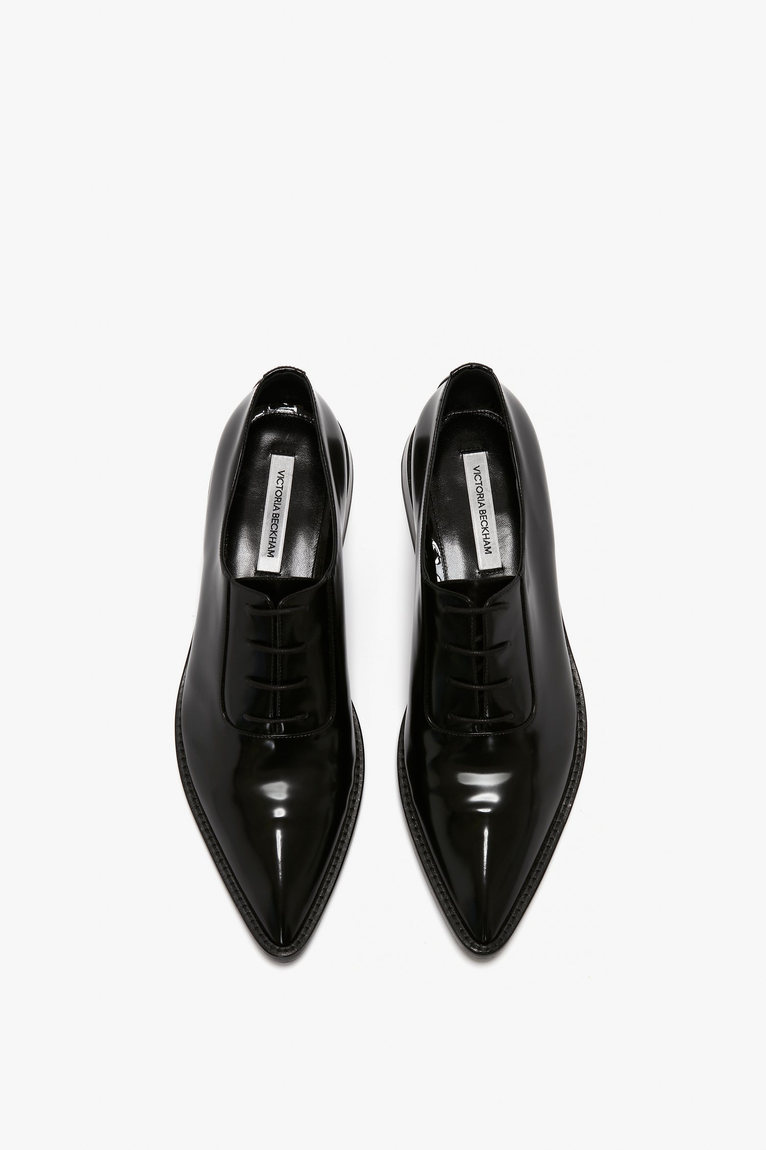 Aerial view of a pair of Pointy Toe Flat Lace Up In Black Brushed Leather by Victoria Beckham, shown against a plain white background.