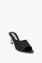 This V Cut Mule In Black Raffia by Victoria Beckham features a moderate heel and a textured raffia design, giving it an effortlessly chic look.