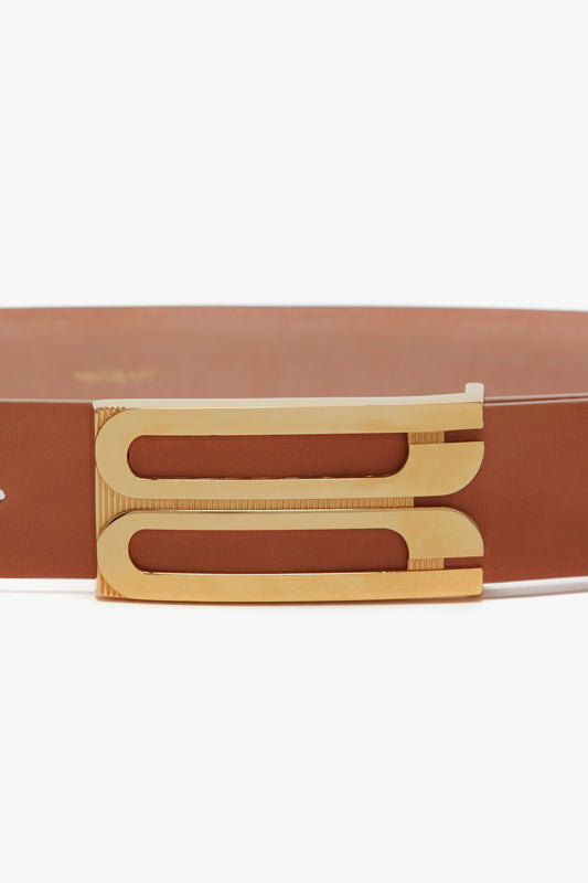 A close-up of the Victoria Beckham Exclusive Jumbo Frame Belt In Nude Leather featuring a sleek, gold-tone geometric buckle.