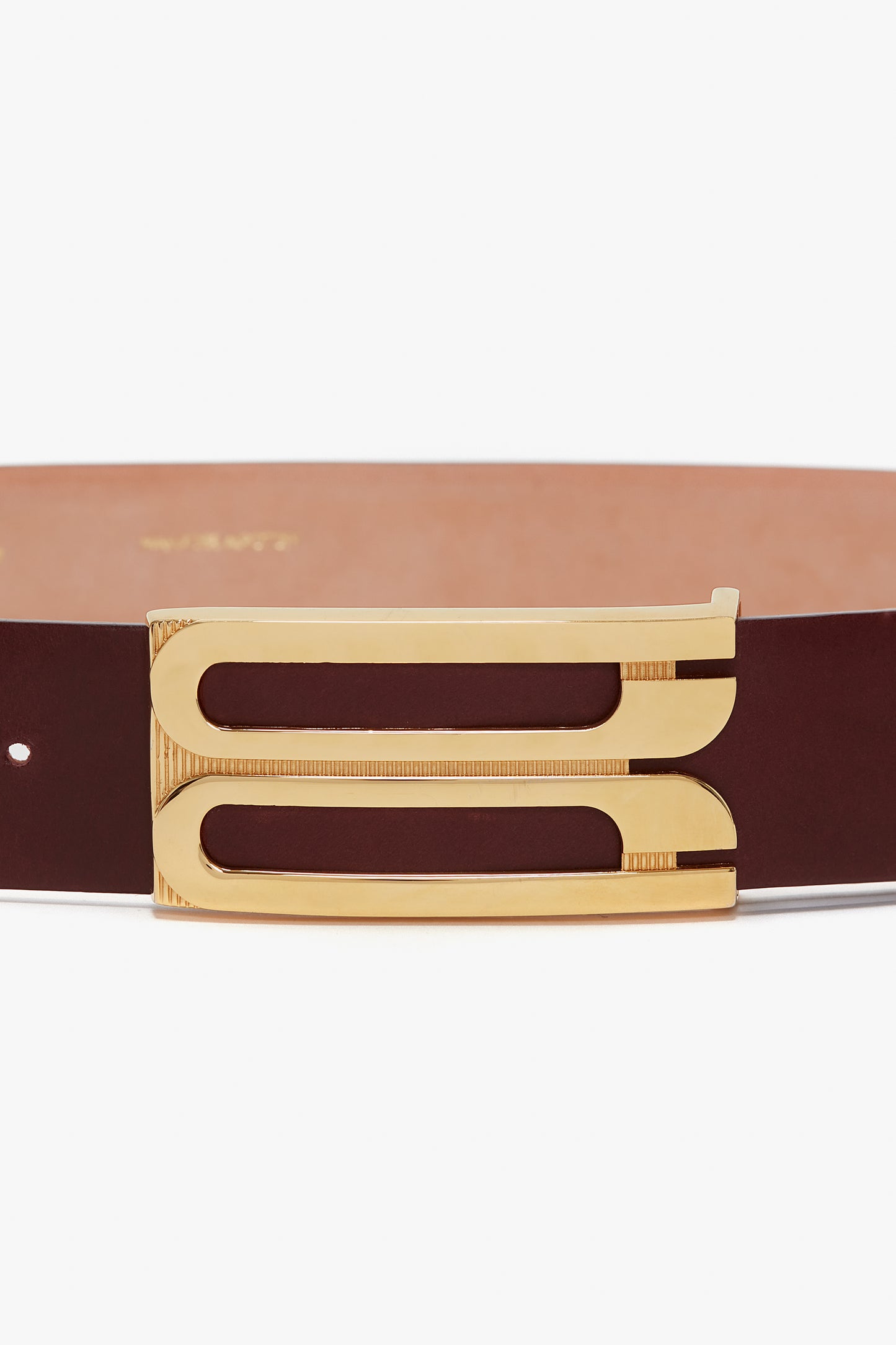 A contemporary brown calf leather belt with a gold rectangular buckle featuring two parallel cut-out slots is replaced by the Jumbo Frame Belt In Burgundy Leather from Victoria Beckham.