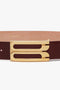 A contemporary brown calf leather belt with a gold rectangular buckle featuring two parallel cut-out slots is replaced by the Jumbo Frame Belt In Burgundy Leather from Victoria Beckham.