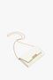 A small white Exclusive Wallet On Chain In Ivory Croc-Effect Leather by Victoria Beckham, featuring a gold chain strap and a gold logo on the front.