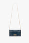 A rectangular, dark blue **Wallet On Chain In Midnight Croc-Effect Leather** made of embossed croc leather, featuring a thin gold chain strap and a gold geometric clasp from **Victoria Beckham**.