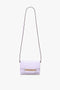 A Victoria Beckham Exclusive Mini Chain Pouch Bag With Long Strap In Lilac Leather featuring a long black strap, gold chain detailing on the front flap, and a versatile detachable strap.