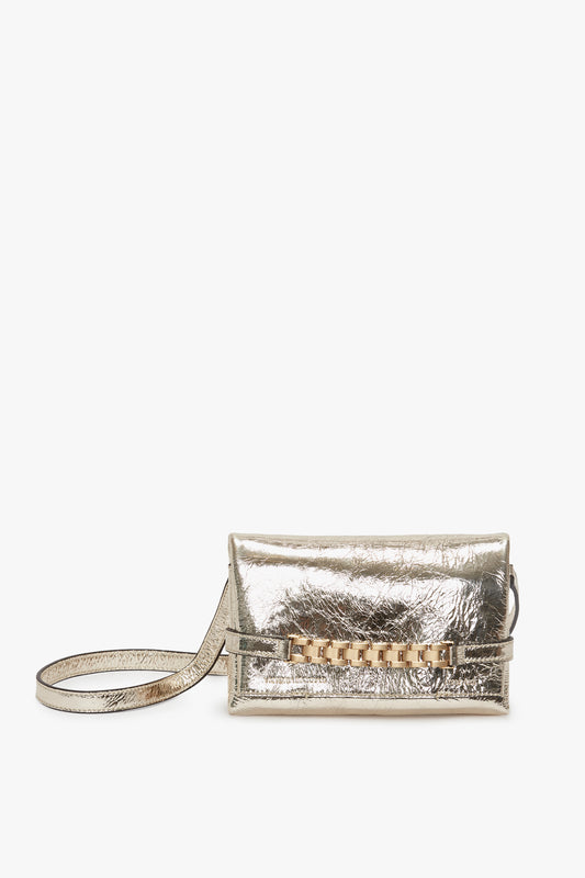 Mini Chain Pouch With Long Strap In Gold Leather clutch by Victoria Beckham, isolated on a white background.
