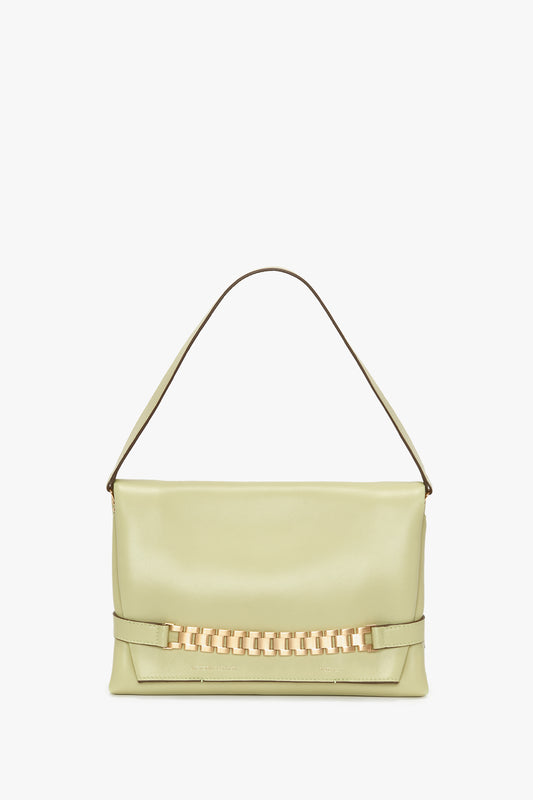 Light green handbag with a single top handle and a gold chain detail on the front, combining elegance and style. This versatile bag, known as the Chain Pouch Bag With Strap In Avocado Leather by Victoria Beckham, is perfect for any occasion.