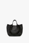 A W11 Medium Tote Bag In Black Leather by Victoria Beckham, featuring two short handles and a sleek, minimal design. Perfect for aficionados of luxury leather goods.