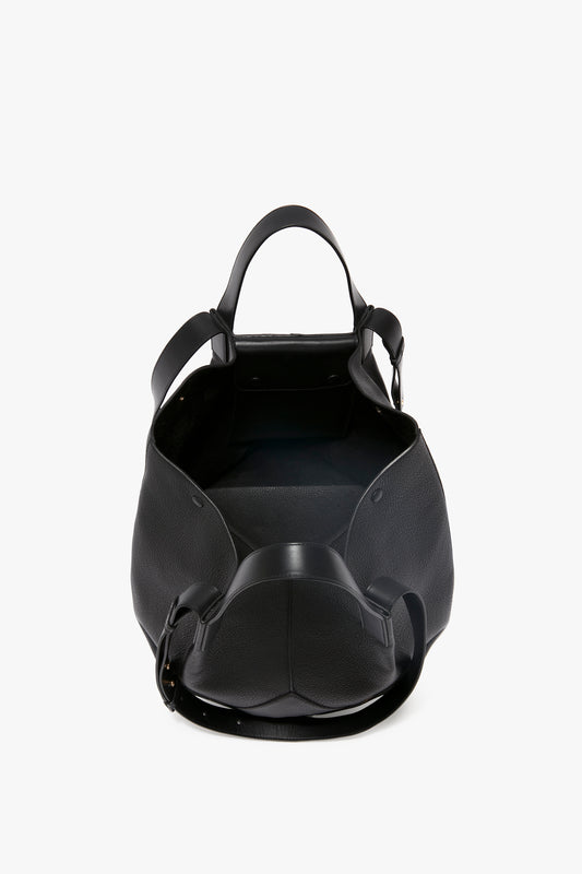 The Victoria Beckham W11 Medium Tote Bag In Black Leather features top handles and an open top, revealing the interior of this exquisite medium tote, epitomizing fine leather goods craftsmanship.