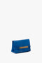 A Mini Chain Pouch Bag With Long Strap In Sapphire Blue by Victoria Beckham with gold-tone hardware, a rectangular metal accent on the front, and a mini chain pouch for added elegance.