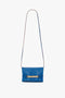 Victoria Beckham Mini Chain Pouch Bag With Long Strap In Sapphire Blue with a long strap and gold chain detail on the front.