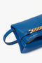 A sapphire blue leather clutch with a gold chain detail and a wrist strap. The brand name "Victoria Beckham" is visible on the front, giving this Mini Chain Pouch Bag With Long Strap In Sapphire Blue an elegant touch.