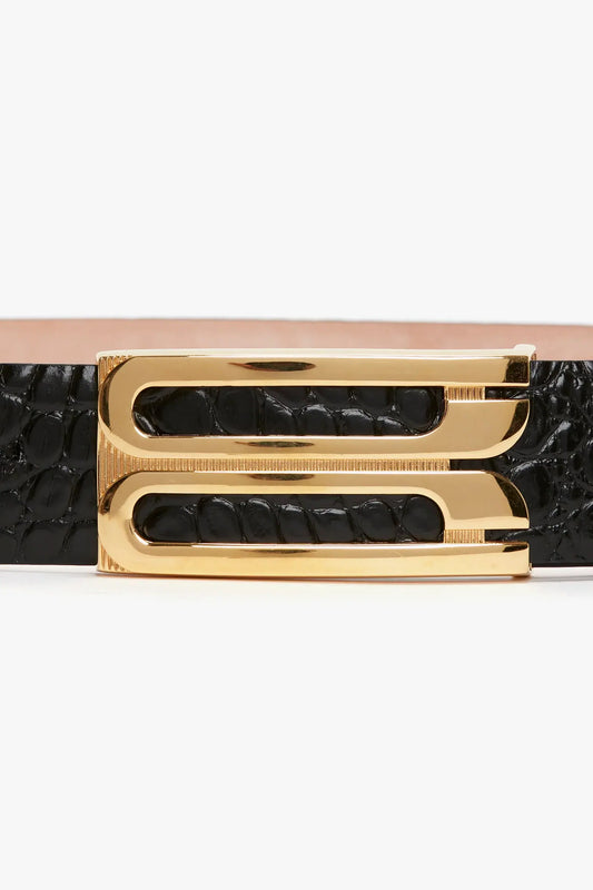 Close-up of a Jumbo Frame Belt In Black Croc Embossed Calf Leather by Victoria Beckham with luxury gold hardware and a gold-toned buckle featuring an interlocking "G" design.