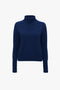 A Victoria Beckham Polo Neck Jumper In Navy with a saddle shoulder design is displayed against a plain white background.