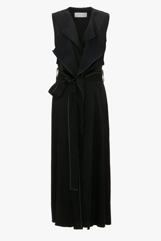 A Victoria Beckham Trench Dress In Black, featuring a draped lapel and long length with a sash-style belt.