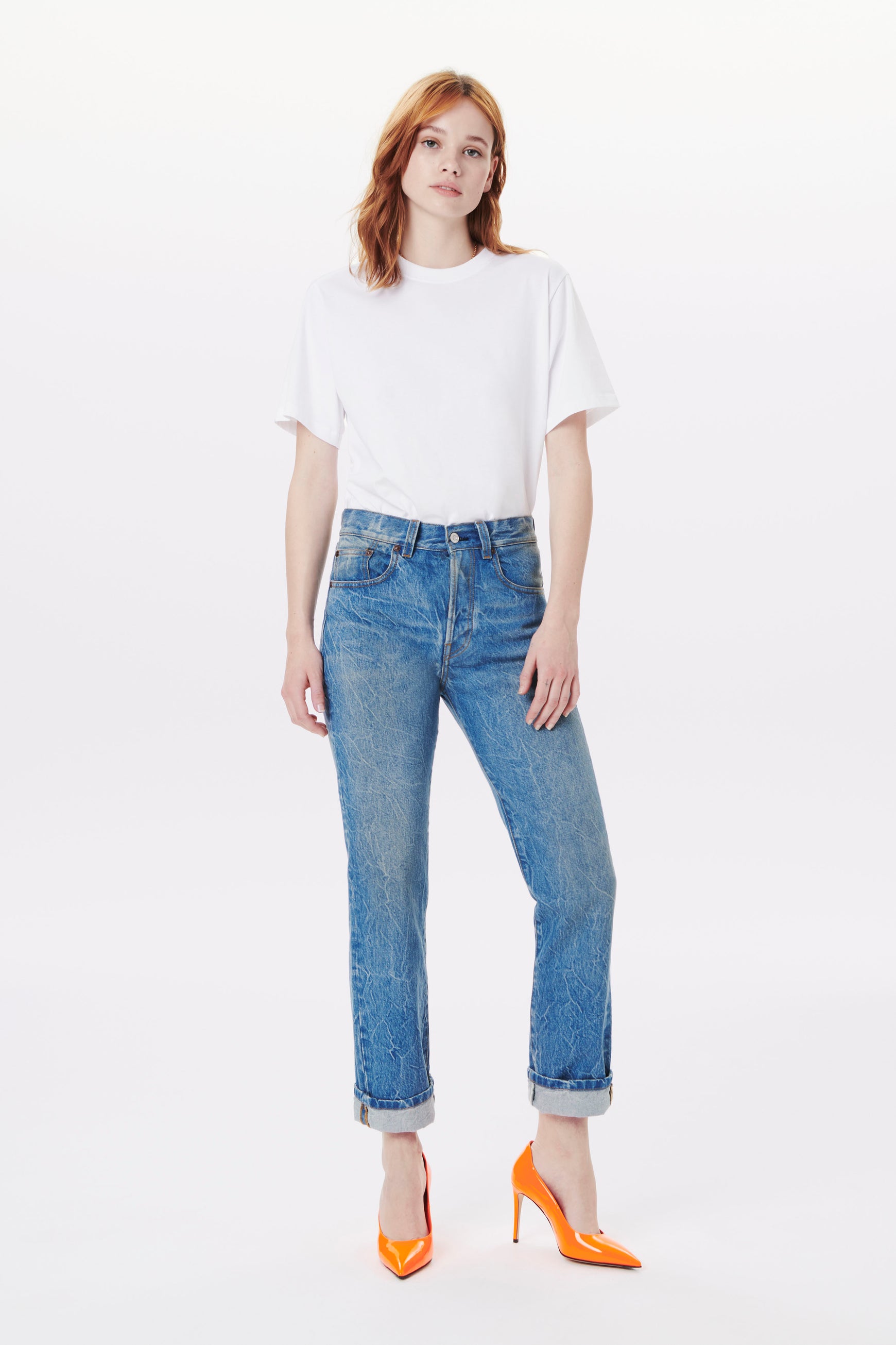 Model wearing the Victoria jean in a slightly cropped length style, perfect for everyday wear. Designer mid rise jeans in a washed denim colour, with a branded leather patch and a classic button fly detail.