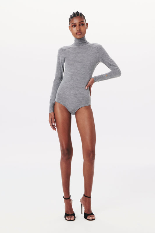 Person wearing the Victoria Beckham Poloneck Bodysuit in Grey Marl and black high-heel sandals, posing against a plain white background.
