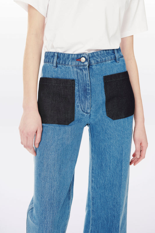 Person wearing Victoria Beckham Alina High Waisted Patch Pocket Jean In 70s Wash and a crisp white shirt.