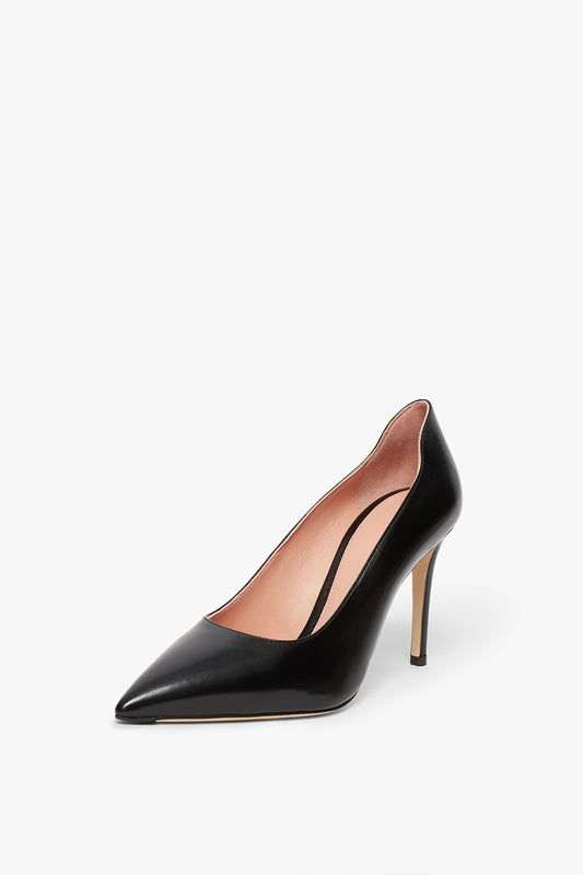 A black VB Pump 90mm in Black with a pointed toe, featuring a stiletto heel and light-colored interior, is positioned against a white background. Handcrafted in Italy by Victoria Beckham, this classic pump exudes elegance and sophistication.