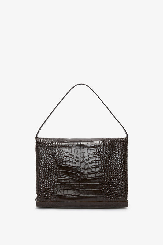 A rectangular, croc-effect Chocolate Brown leather handbag with a single shoulder strap and versatile styling, set against a white background. The Jumbo Chain Pouch Bag In Chocolate Croc-Effect Leather by Victoria Beckham.