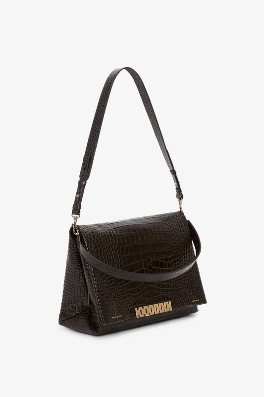 Jumbo Chain Pouch Bag In Chocolate Croc-Effect Leather by Victoria Beckham with a croc-effect pattern, gold hardware, a front flap, and a single shoulder strap—ideal for versatile styling.