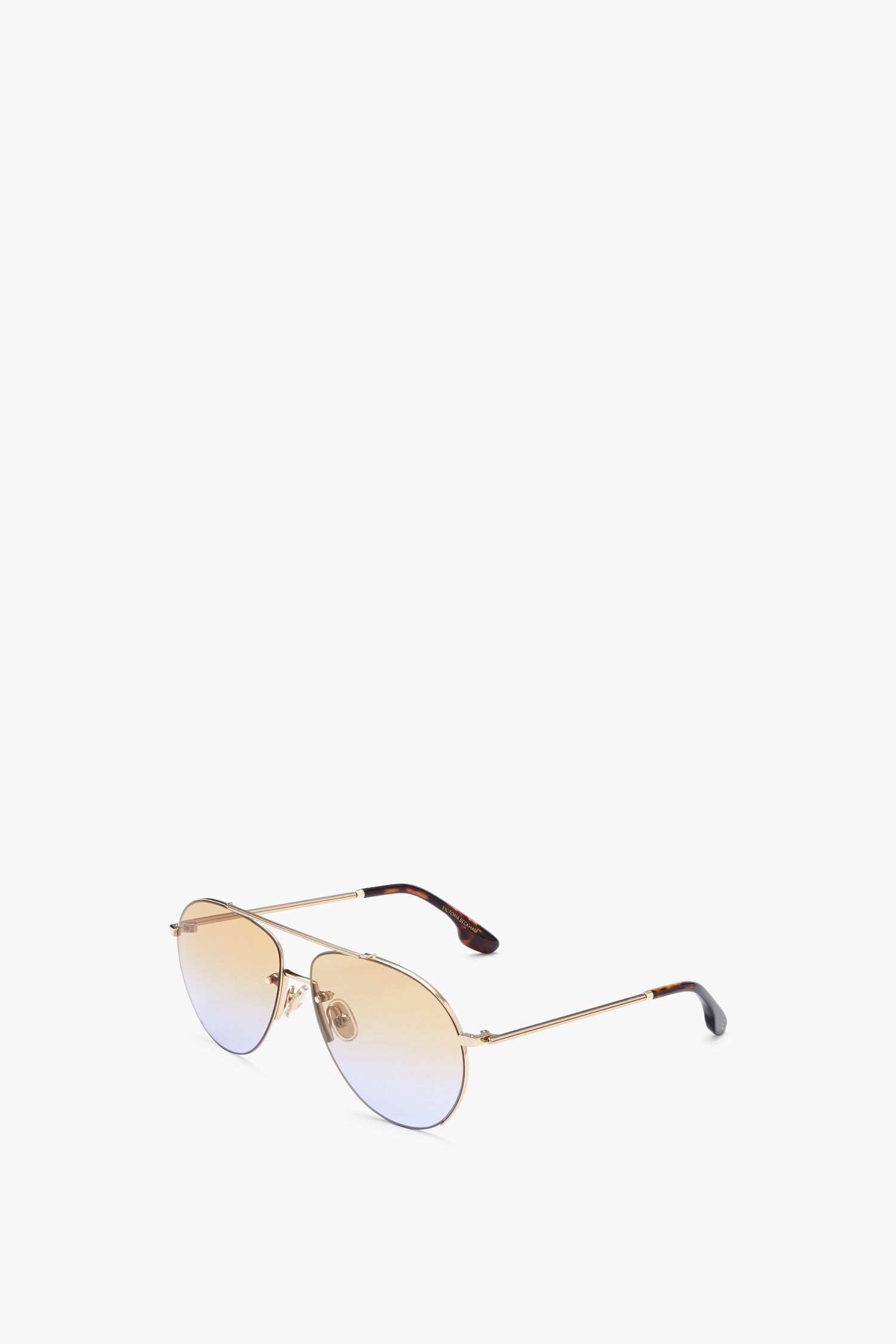 A pair of Fine Aviator in Gold Honey sunglasses by Victoria Beckham with gradient Zeiss lenses and thin gold metal frames, offering UV protection, placed against a white background.