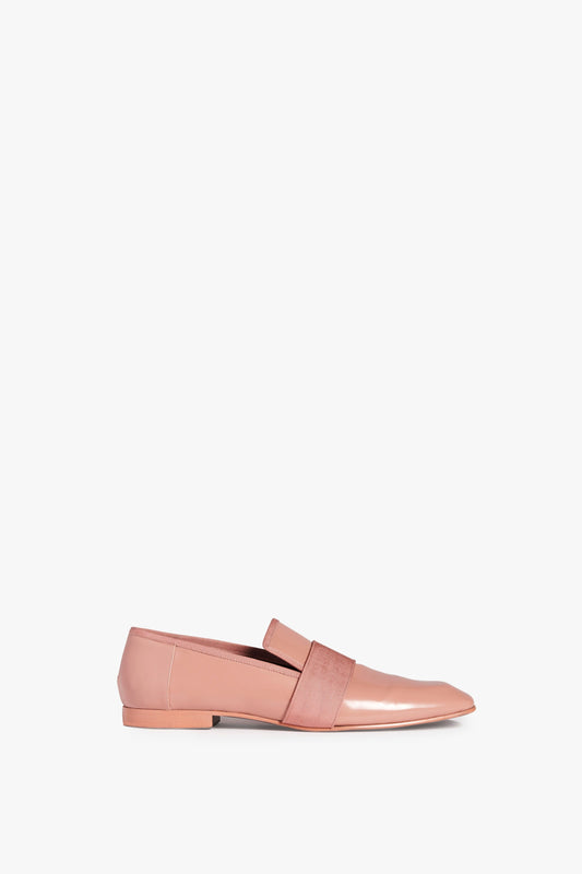 A single Debbie Loafer in Rose by Victoria Beckham in rose-coloured patent leather with a wide matching strap across the front is shown against a plain white background.