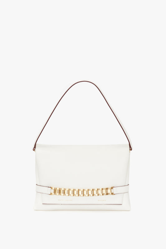 A Victoria Beckham Chain Pouch Bag with Strap In White Leather, crafted from luxurious Nappa leather, featuring a single strap and a fold-over flap with a gold geometric accent. This elegant piece also includes a detachable strap for added versatility.