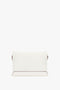 A Victoria Beckham Chain Pouch Bag with Strap in White Leather made from luxurious Nappa leather with subtle brown accents at the edges, displayed against a plain white background. It features a detachable strap for versatile styling options.