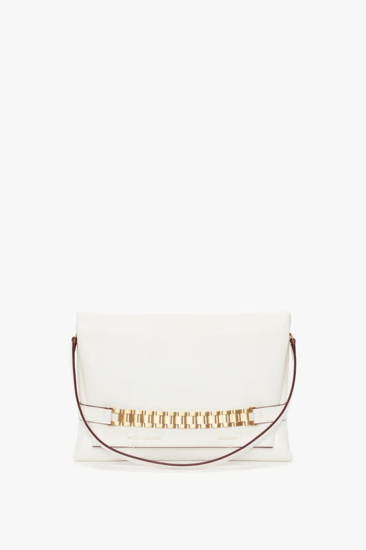 A white rectangular Chain Pouch Bag with Strap In White Leather by Victoria Beckham with a gold chain detail on the front and a thin maroon detachable strap.