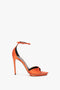 A single Pointy Toe Stiletto Sandal in Orange Satin by Victoria Beckham, featuring an ankle strap and open toe with a leg-lengthening platform sole, on a white background.