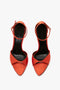 A pair of red Pointy Toe Stiletto Sandals with ankle straps and leg-lengthening platform soles, viewed from above, on a white background.

should be replaced with:

A pair of orange satin Pointy Toe Stiletto Sandals with ankle straps and leg-lengthening platform soles from Victoria Beckham, viewed from above, on a white background.