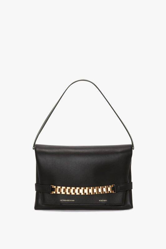 A black handbag crafted from Nappa leather, featuring a gold-tone chain detail across the front and a single shoulder strap has been replaced with the "Chain Pouch Bag with Strap In Black Leather" by Victoria Beckham.