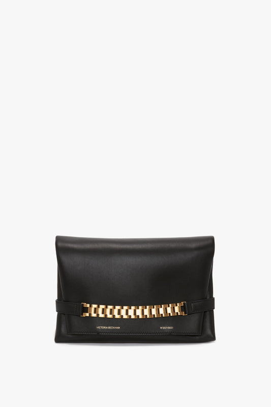 A Chain Pouch Bag with Strap In Black Leather by Victoria Beckham featuring a gold-tone chain detail on the front and a detachable strap for versatile styling.