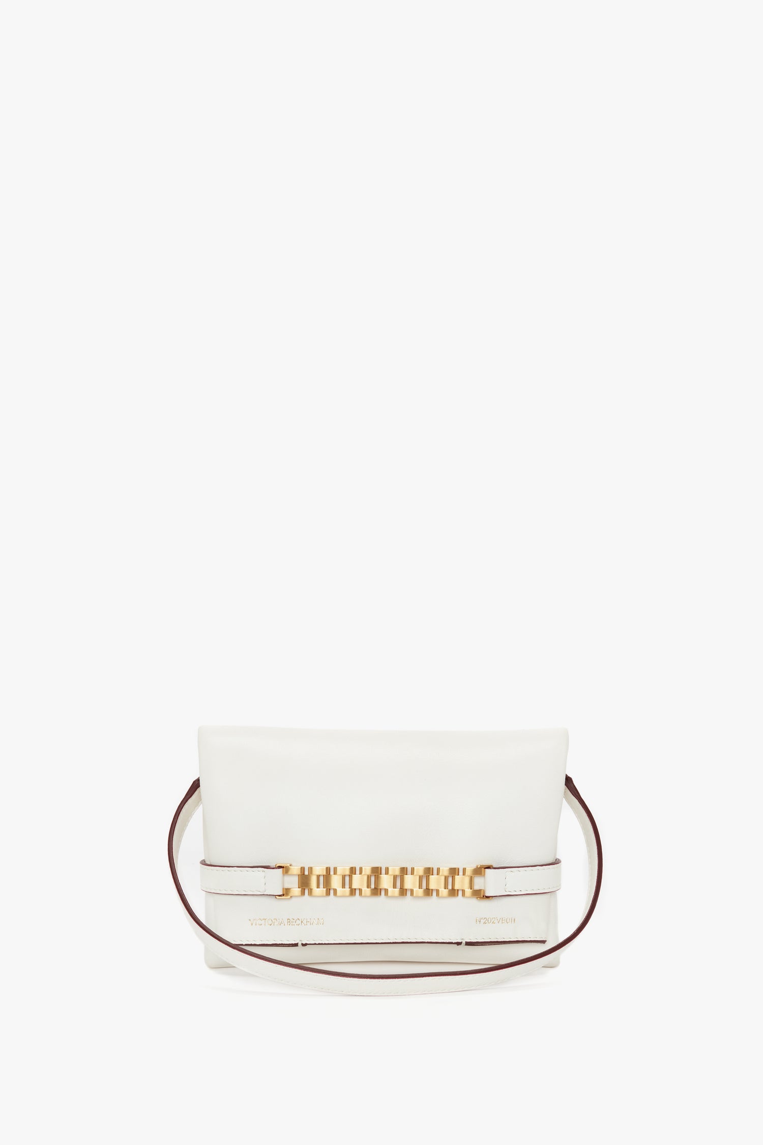 A Mini Chain Pouch Bag In White Leather, crafted from luxurious Nappa leather, adorned with gold accents on the front, and featuring a thin maroon detachable strap. Branded with "Victoria Beckham" and "TRIPON 1997" on the bottom, this mini pouch embodies elegance.