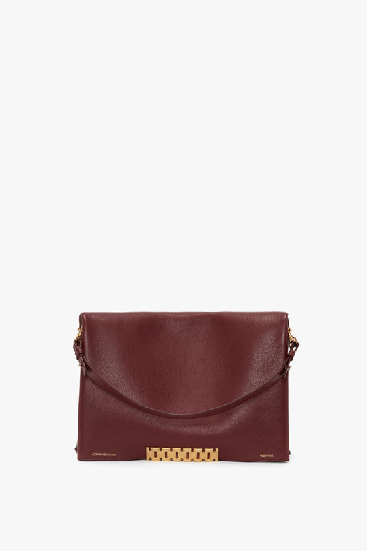 A Jumbo Chain Pouch Bag In Bordeaux by Victoria Beckham, featuring a detachable gold chain strap.