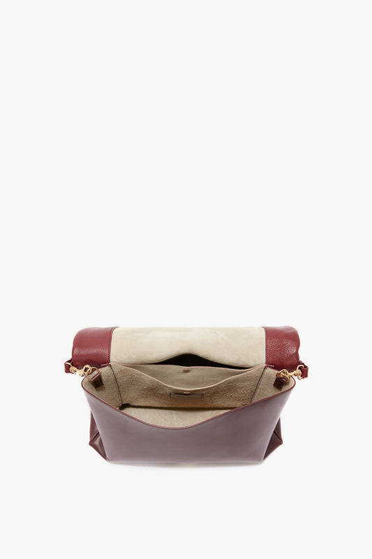 Open Jumbo Chain Pouch Bag In Bordeaux by Victoria Beckham showing interior compartments and pockets, with a flap over the top and a detachable strap.