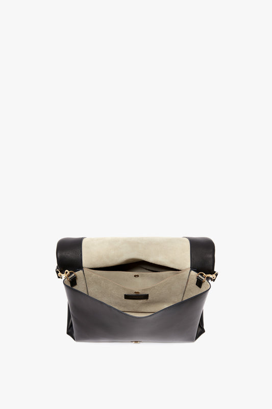 A Jumbo Chain Pouch Bag In Black Leather by Victoria Beckham with a beige interior and open flap, revealing pockets and a magnetic clasp.