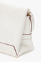 A close-up image of a white, folded Mini Chain Pouch Bag In White Leather by Victoria Beckham with a detachable strap, handle, and gold clasp detail.