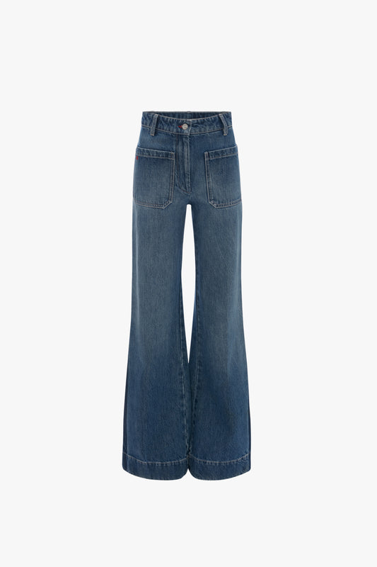 Wide-legged blue Alina High Waisted Jean In Shadow Wash by Victoria Beckham with a high waist and front patch pockets, shown from the back on a plain white background, emphasize a 70s-inspired flared leg and classic denim silhouette.