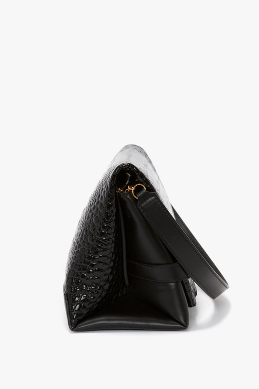 Side view of a black Victoria Beckham Chain Pouch Bag With Strap In Black Croc-Effect Leather with a textured, croc-embossed leather exterior and a strap, against a plain white background.