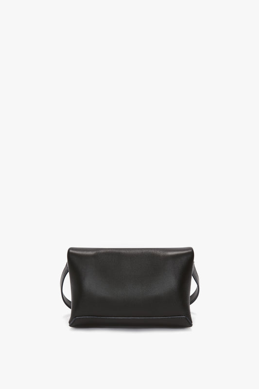 A classic Mini Chain Pouch Bag In Black Leather with a minimalist design by Victoria Beckham features gold-tone hardware and a strap on each side, placed against a plain white background.