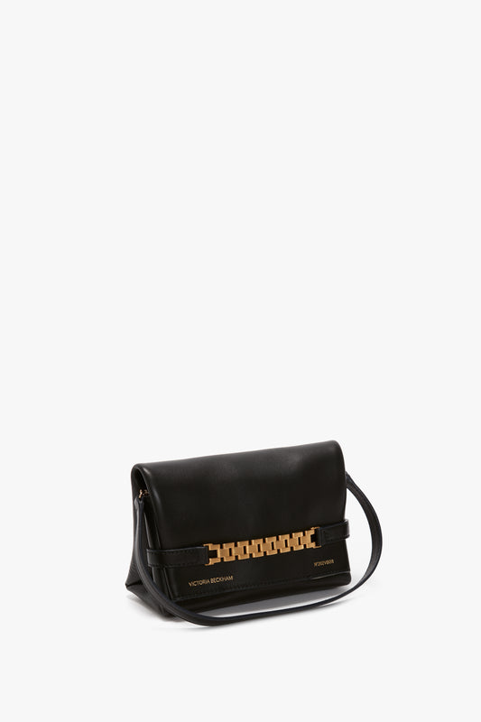 A classic black leather shoulder bag with gold-tone hardware and a chain detail, labeled "Victoria Beckham" on the front bottom corner. This Mini Chain Pouch Bag In Black Leather by Victoria Beckham features a sophisticated strap that effortlessly elevates any outfit.